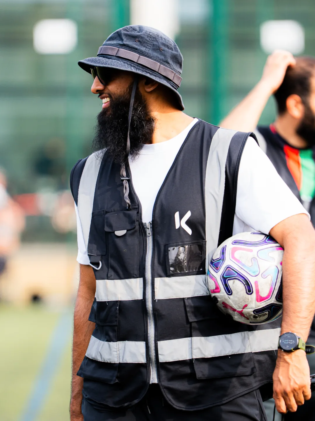A volunteer in a hi-vis vest holding the match ball