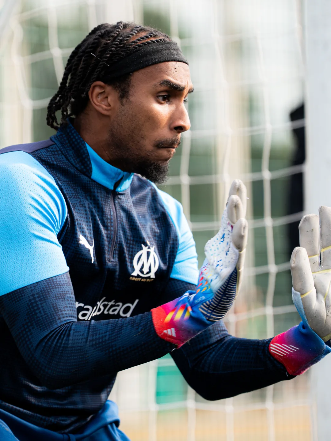 A goalkeeper stretching to make a save