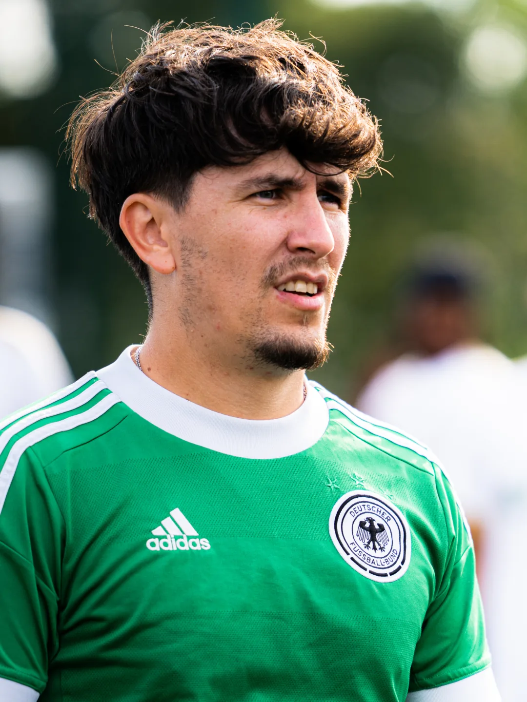 A player in a green shirt watching play